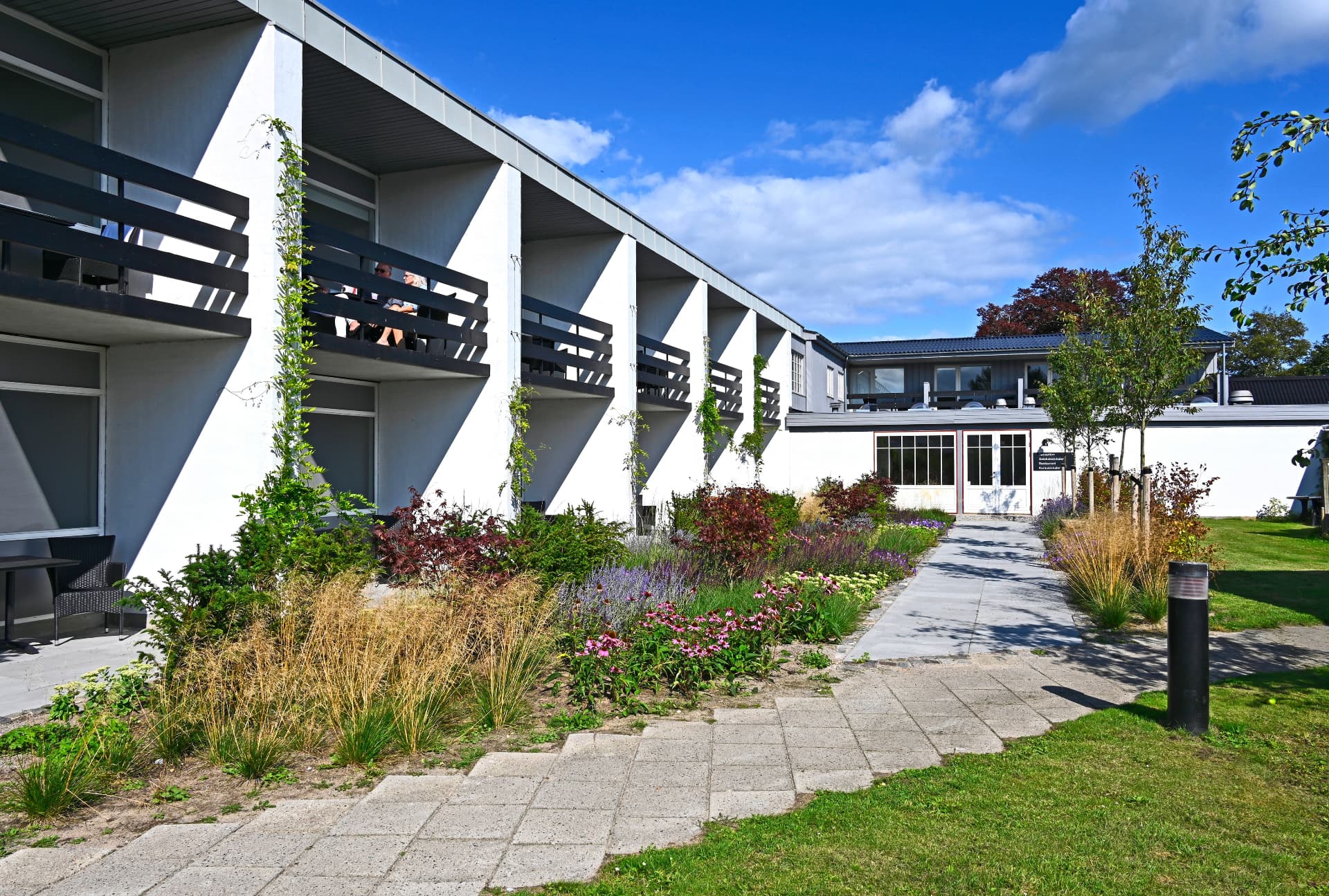 Hotellets facade med altaner og grøn have